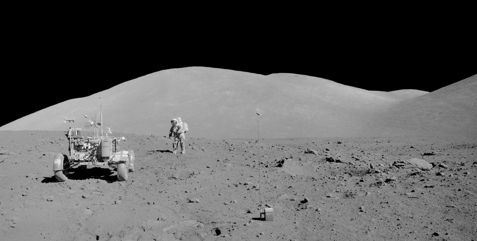 Black and white photo of astronaut Harrison Schmitt collecting samples from the Moon's core during Apollo 17 mission