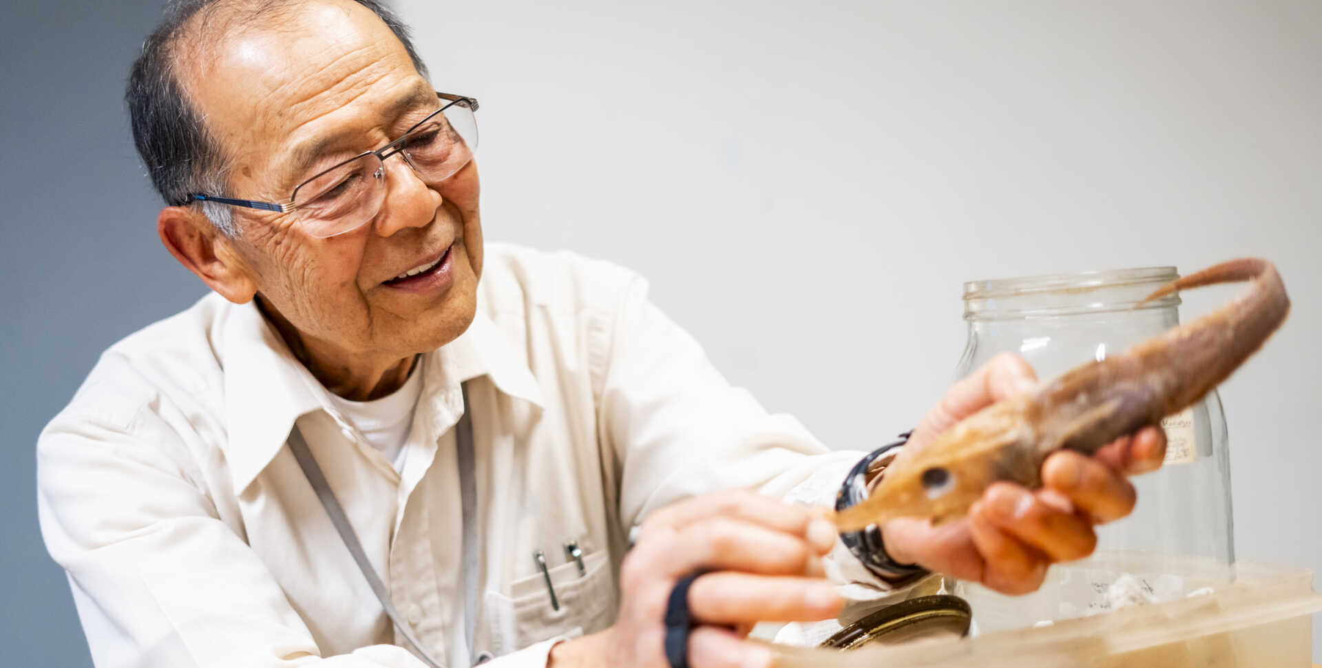 Academy curator Tomio Iwamoto holds a preserved grenadier fish specimen. Photo by Gayle Laird