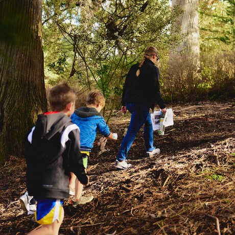 Academy staff member leads donor kids on a walk in the woods