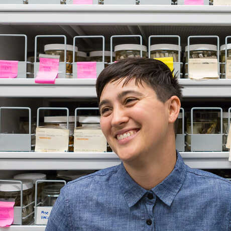 Arachnologist Lauren Esposito in front of a wall of preserved insect specimens