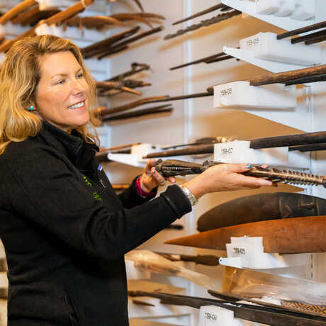 Shannon Tushingham holds an arrow in the anthropology collections. 